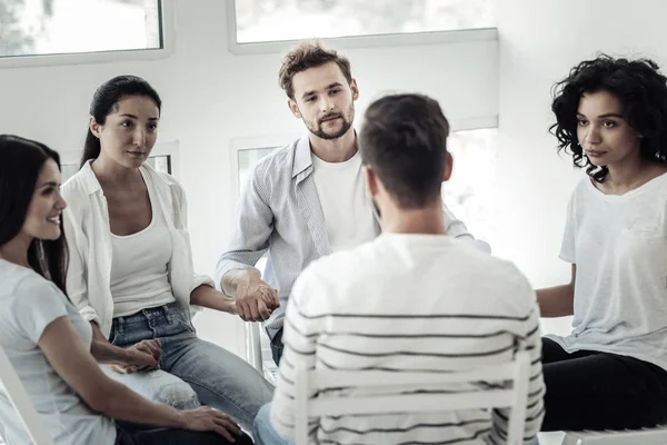 Jóvenes positivos tomados de la mano — Foto de Stock