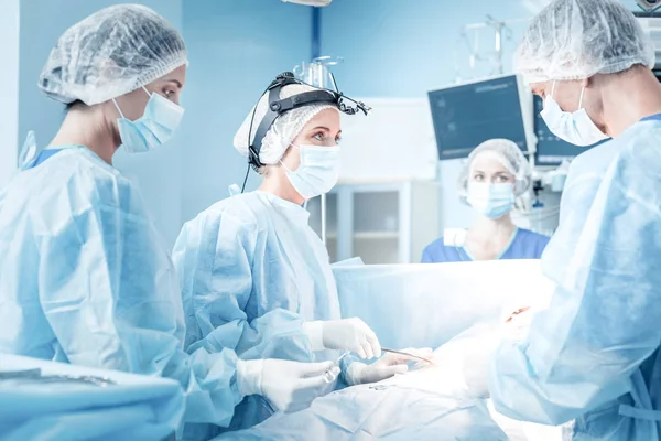 Smart nice surgeons working in team — Stock Photo, Image