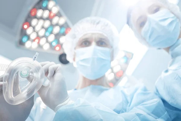 Professional smart surgeon holding a mask — Stock Photo, Image