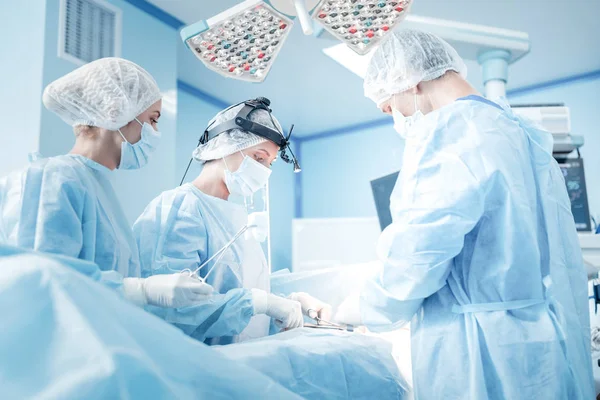 Cirurgiões inteligentes profissionais salvando a vida dos pacientes — Fotografia de Stock