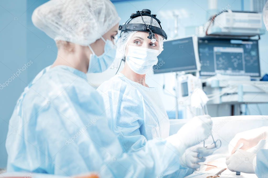 Smart nice doctor standing near her colleague