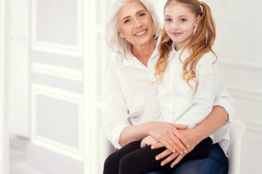 Neşeli büyükannesi kucağına oturan güzel küçük hanım