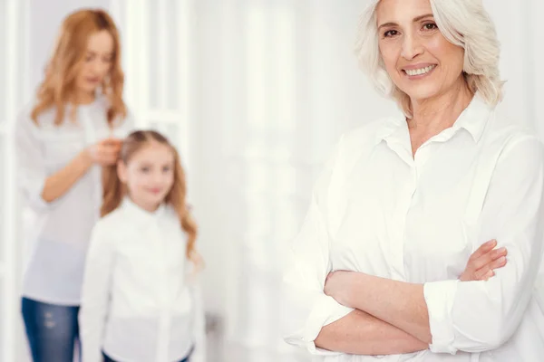 Charmig äldre dam poserar med dotter och dotterDotter dressing bakom — Stockfoto