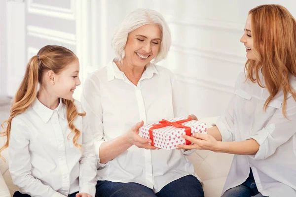 Liefdevolle moeder en dochter geven aanwezig om hun prachtige oma — Stockfoto