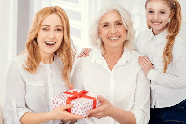 Überraschte Frau erhält Geschenk von Mutter und Tochter — Stockfoto