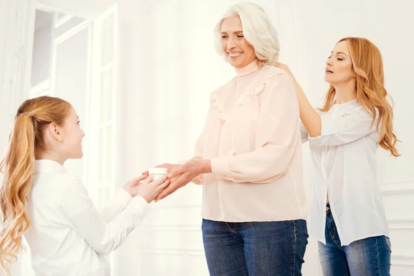 Radiant granny getting help from loving daughter and grandchild