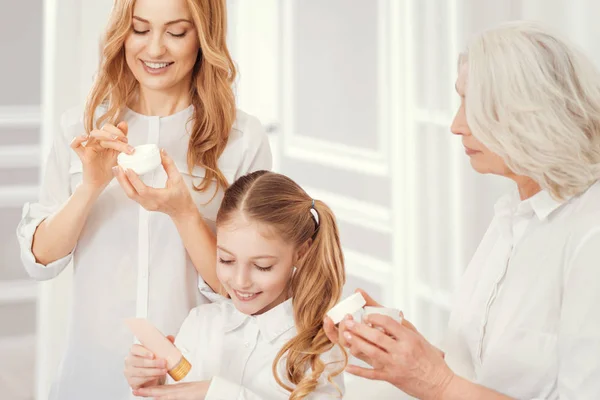 Joyful women moisturizing their skin — Stock Photo, Image