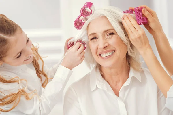 Strahlende Oma experimentiert im Familienkreis mit Frisuren — Stockfoto