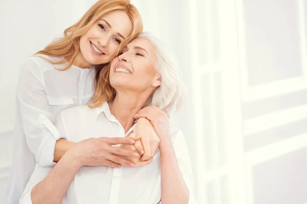 Tender mature woman embracing her senior mom with love — Stock Photo, Image