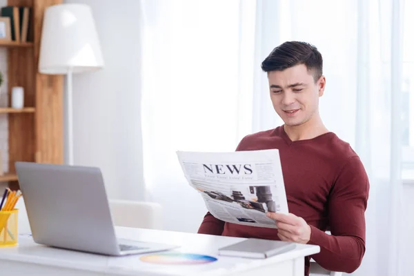 Angenehmer männlicher Freiberufler untersucht Zeitung — Stockfoto