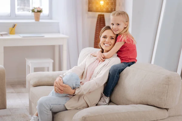 Menina sorridente bonito abraçando sua mãe — Fotografia de Stock