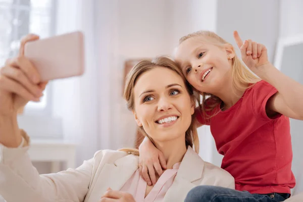 Happy positive mother and daughter taking a selfie — Stock Photo, Image