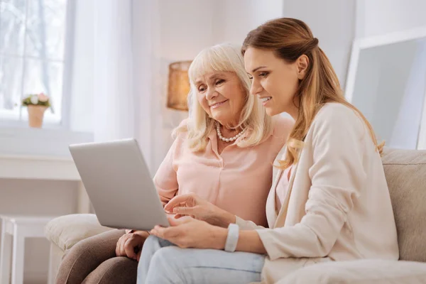 Mujer anciana agradable mirando la pantalla del ordenador portátil — Foto de Stock