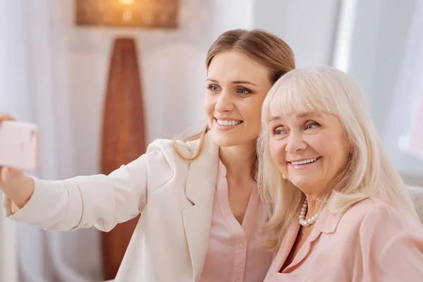 Cheerful positive women looking into the smartphone camera — Stock Photo, Image