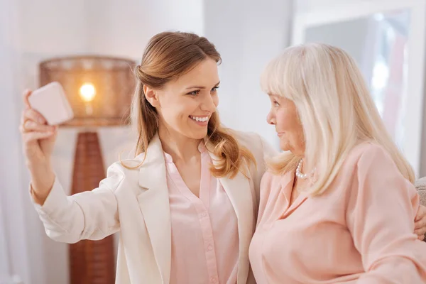 Positive young woman standing together with her mother — Stock Photo, Image