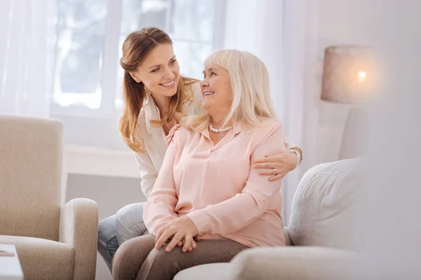 Nöjd äldre kvinna tittar på hennes dotter — Stockfoto