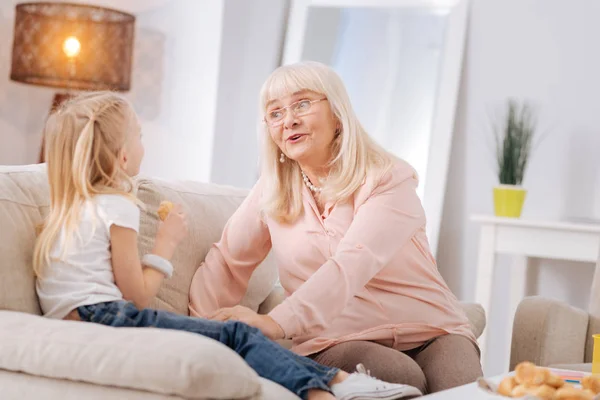 Freudige alte Frau lächelt ihrer Enkelin zu — Stockfoto