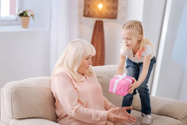 Leuke positieve meisje geven een cadeautje — Stockfoto