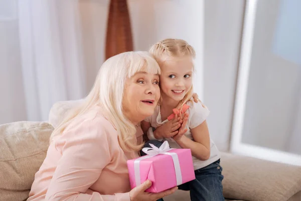 Entzückte alte Frau umarmt ihre Enkelin — Stockfoto