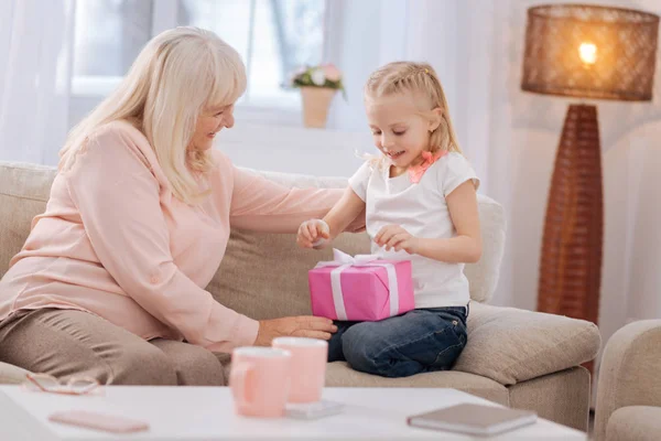 Ziemlich aufgeregtes Mädchen öffnet ihr Geschenk — Stockfoto