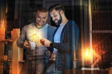 Tablette fotoğrafları izlerken gülümseyen pozitif arkadaşlar