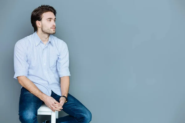 Agradable hombre triste sentado en un taburete — Foto de Stock