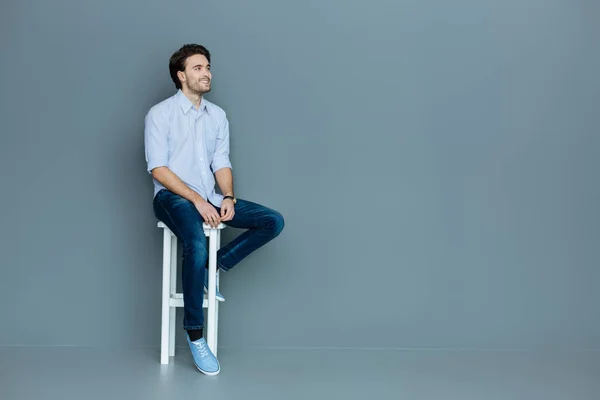 Glad positiv man sittande på en pall — Stockfoto