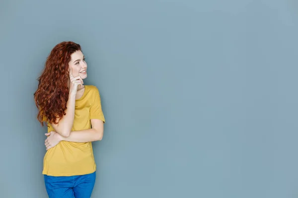 Cheerful delighted woman touching her cheek