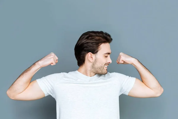 Atraente homem forte mostrando seu bíceps — Fotografia de Stock
