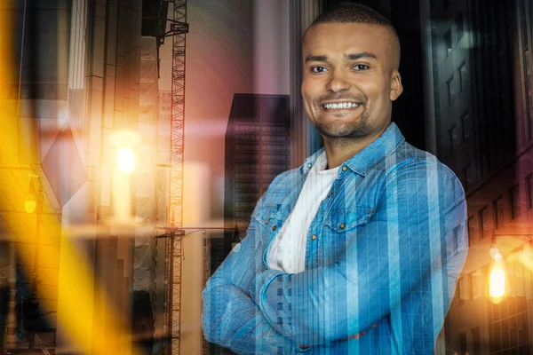 Uomo positivo sorridente mentre si rilassa dopo la sua giornata di lavoro — Foto Stock