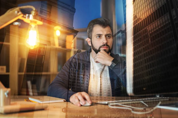 Smarta arbetare tänkande medan du tittar på skärmen på hans dator — Stockfoto