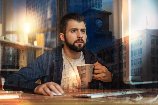 Geconcentreerde man staren naar het scherm terwijl het drinken van thee — Stockfoto