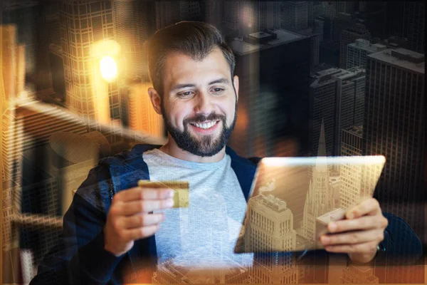 Positive man smiling while doing online shopping — Stock Photo, Image