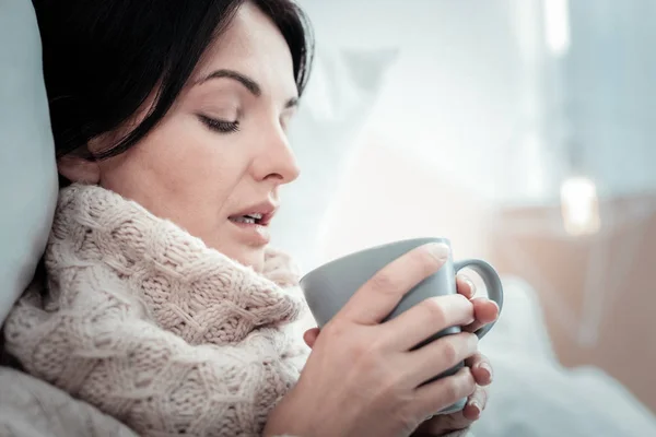 Unsatisfied pretty woman holding a cup and looking down. — Stock Photo, Image