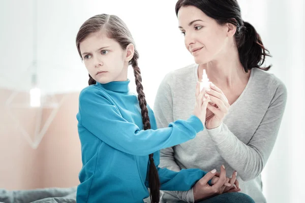 Triste ragazza disturbata che si presenta e si tocca a spray naso . — Foto Stock