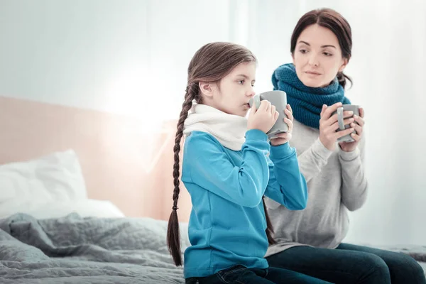 Bambina malata seduta a bere tè . — Foto Stock