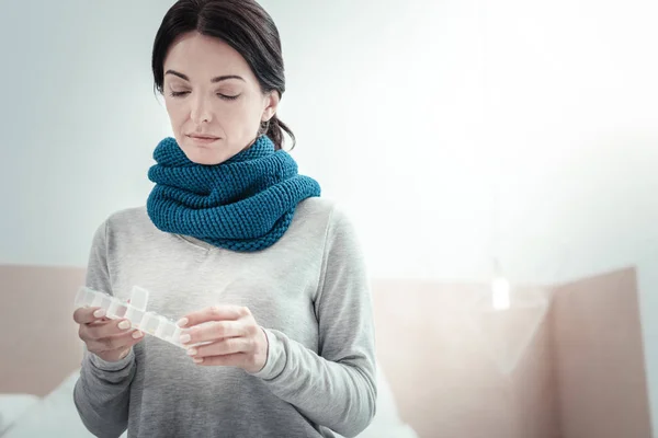 Mujer seria concentrada mirando hacia abajo y sosteniendo un disco . — Foto de Stock