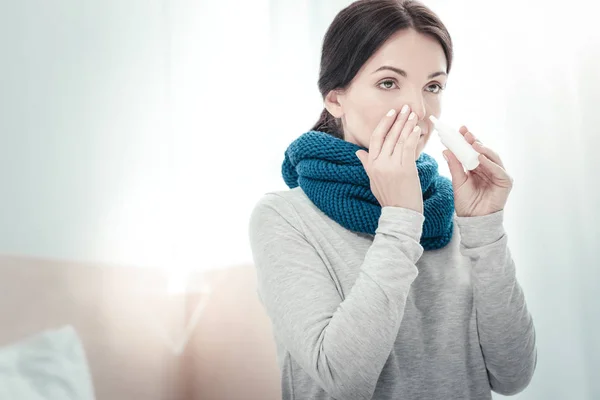 Mulher doente grave usando spray nasal tocando em seu nariz . — Fotografia de Stock
