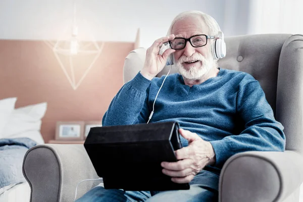 Alegre anciano arreglando sus gafas — Foto de Stock