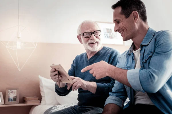 Feliz hombre positivo apuntando a la foto — Foto de Stock