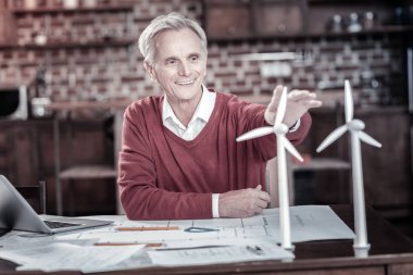 Yel değirmeni üzerinde çalışan mutlu erkek mühendisi