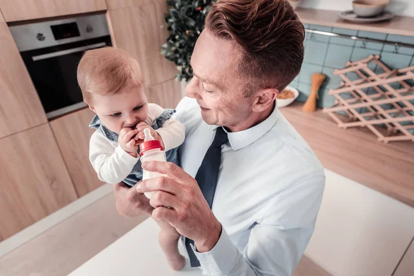 Nahaufnahme der entzückten Brünette, die ihr Kind füttert — Stockfoto