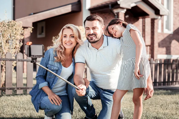 Vrolijke aangename familie glimlachend en het maken van groepsfoto. — Stockfoto