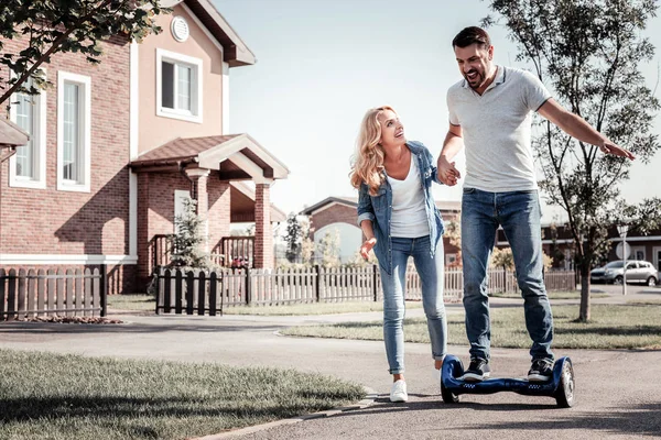 Verraste verbaasd mens glimlachend en staande op de zelfbalancerende scooter. — Stockfoto