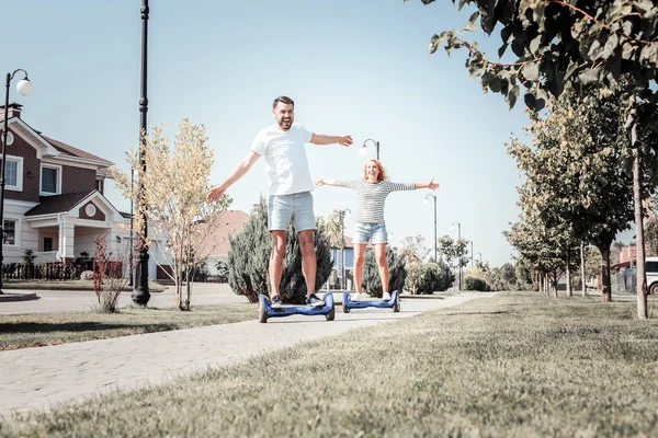 Trevliga glada par skakar hand rider på självbalanserande skoter. — Stockfoto