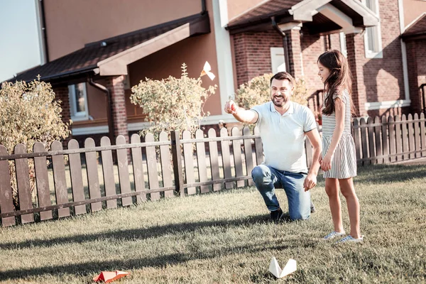 Tevreden zorgzame vader het papieren vliegtuig gooien en glimlachen. — Stockfoto