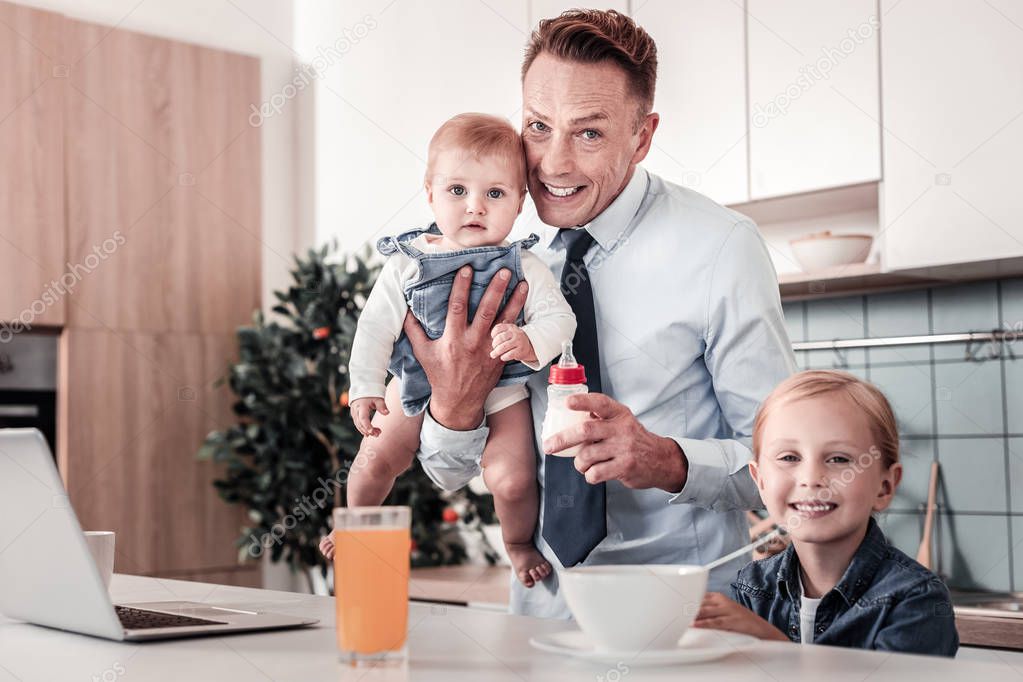 Pleased young father spending time with children