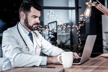 Oturma ve dizüstü bilgisayar kullanarak ciddi işgal doktor.