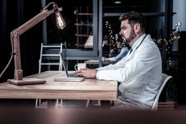 Oturma ve çalışma yakışıklı nitelikli sağlık görevlisi.