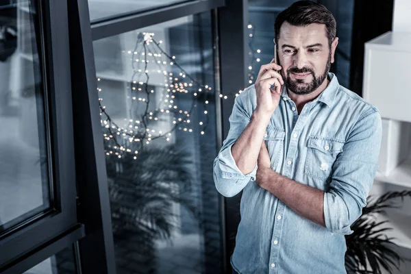 Agréable bel homme debout et ayant une conversation téléphonique . — Photo